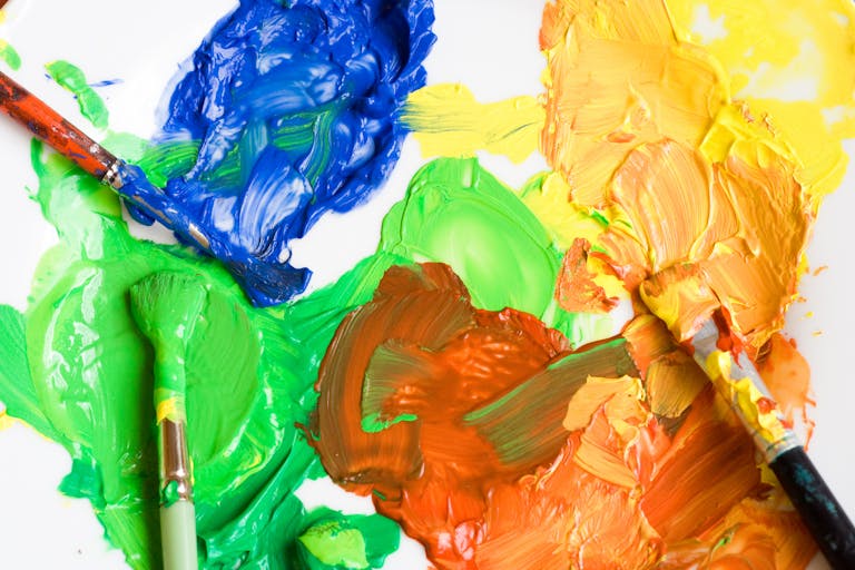 Close-up of a colorful paint palette with brushes showing creativity and art expression.